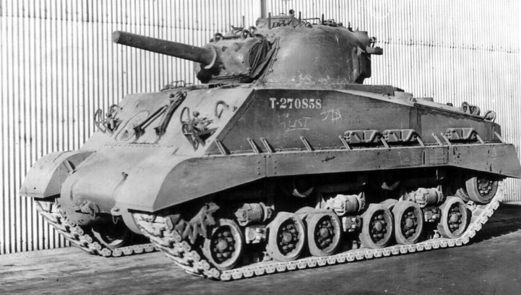 M4A3(105) HVSS Sherman sitting in front of a military hangar